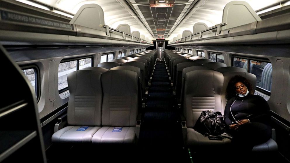 PHOTO: A lone passenger sleeps in an empty Amtrak car as the train pulls into Penn Station, on April 9, 2020, in Baltimore.
