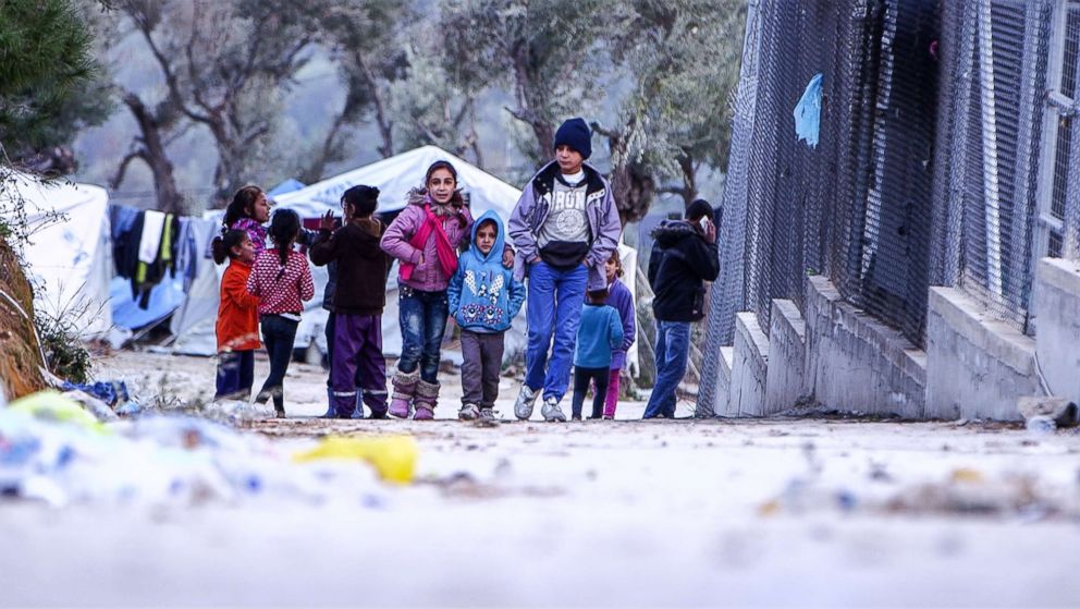 PHOTO: Anas Hommada, 14, and his younger siblings walk in Lesbos' Moria refugee camp.