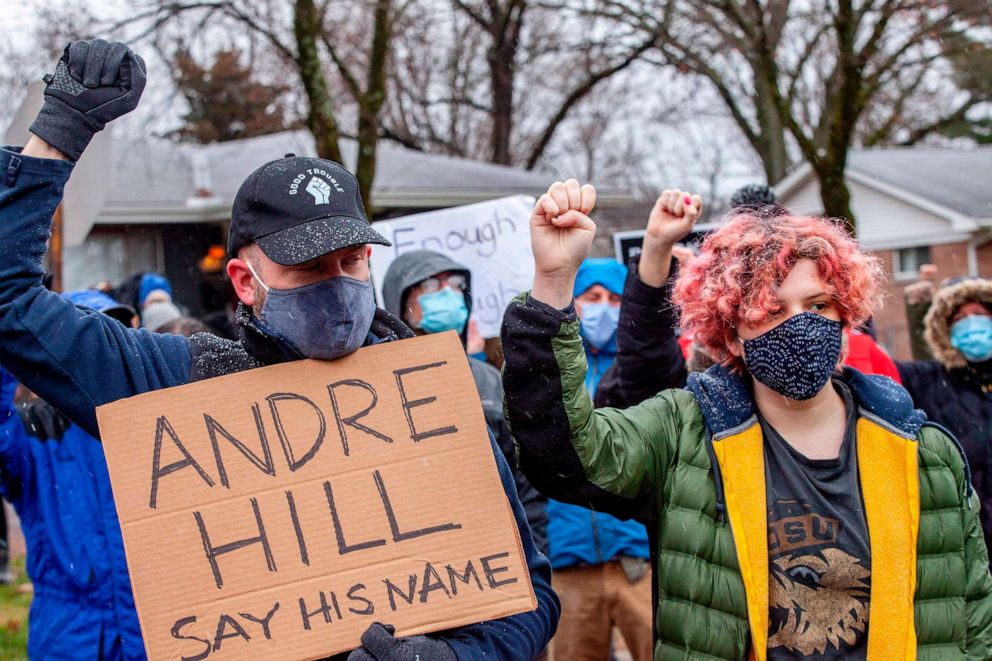 PHOTO: Protesters raise their fists and observe a moment of silence during a demonstration against the police killing of Andre Hill in the neighborhood where Hill was shot, in Columbus, Ohio on Dec. 24, 2020.