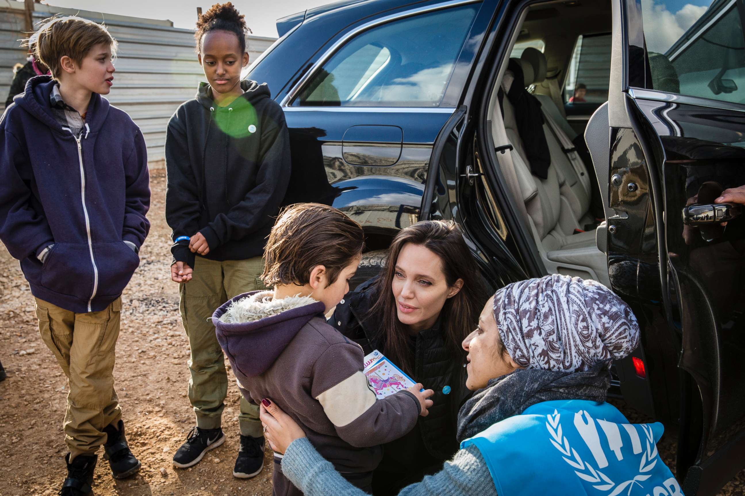 PHOTO: Special envoy Angelina Jolie accompanied on the trip by daughters Shiloh, and Zahara, speak with a young Syrian refugee boy outside his home, Jan. 28, 2018, in Zaatari refugee camp, Jordan. 