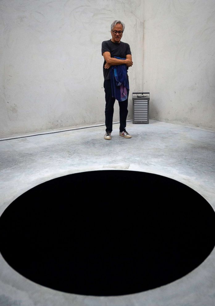 PHOTO: Anish Kapoor stands next his artwork "Descent into limbo" during the opening of his exhibition entitled "Works, thoughts, experiments" at the Serralves Foundation in Porto, on July 6, 2018.