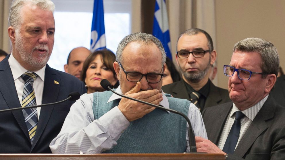 Mohamed Labidi, the vice-president of the Quebec Islamic Cultural Centre, is comforted by Quebec Premier Philippe Couillard and Quebec City mayor Regis Labeaume during a news conference Monday, Jan. 30, 2017, about the fatal shooting at the Quebec mosque on Sunday.