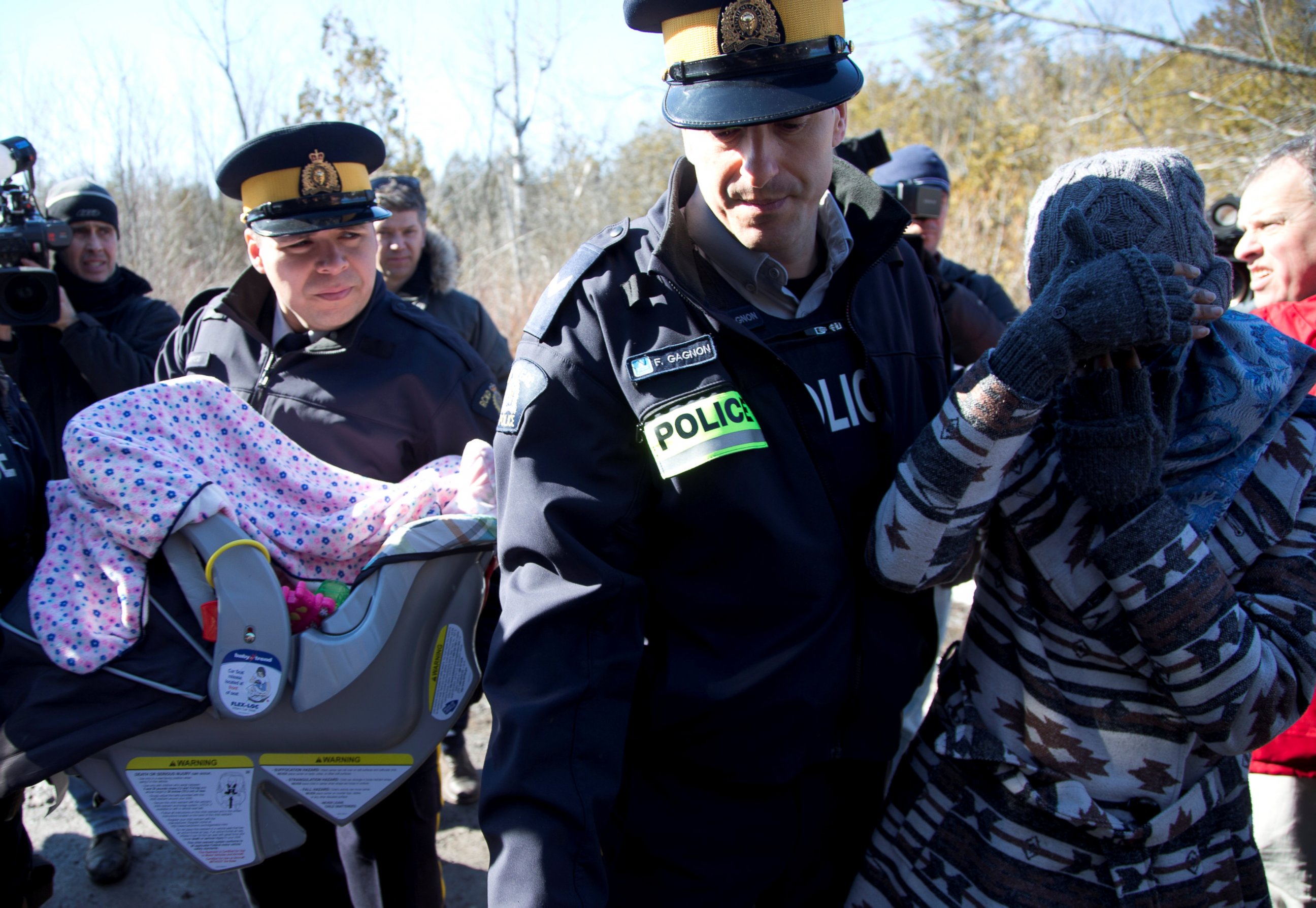 PHOTO: A mother and her child are taken into custody by Royal Canadian Mounted Police officers after crossing U.S.-Canada border into Hemmingford, Quebec, Feb. 20, 2017.
