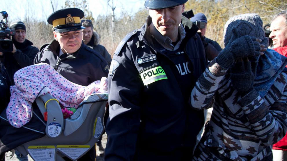 PHOTO: A mother and her child are taken into custody by Royal Canadian Mounted Police officers after crossing U.S.-Canada border into Hemmingford, Quebec, Feb. 20, 2017.