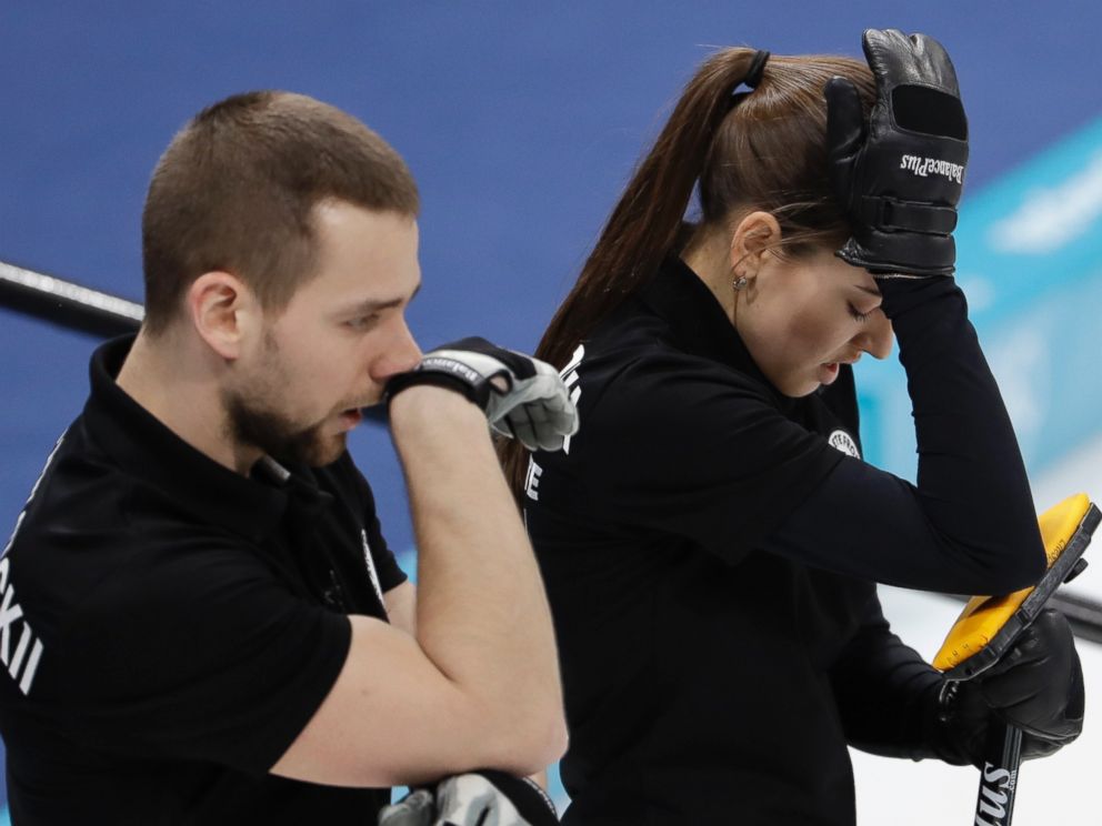Russian athletes Anastasia Bryzgalova, right, and Aleksandr Krushelnitckii look down during the mixed doubles semi-final curling match against Switzerland Jenny Perret and Martin Rios at the Winter Olympics in South Korea, Monday, Feb. 12, 2018.