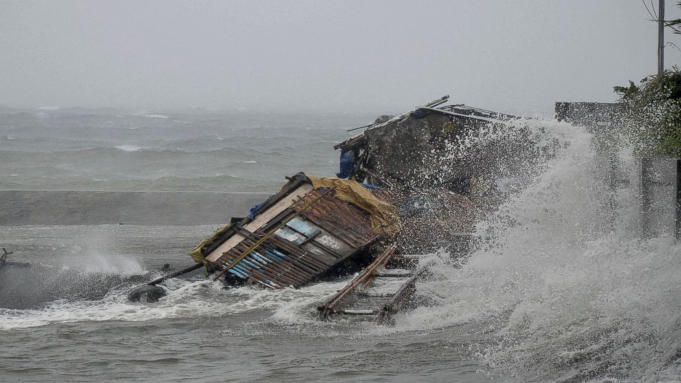 A house is engulfed by the storm surge brought about by powerful Typhoon Haiyan that hit Legazpi city, Albay province Friday Nov.8, 2013, about 325 miles south of Manila, Philippines.