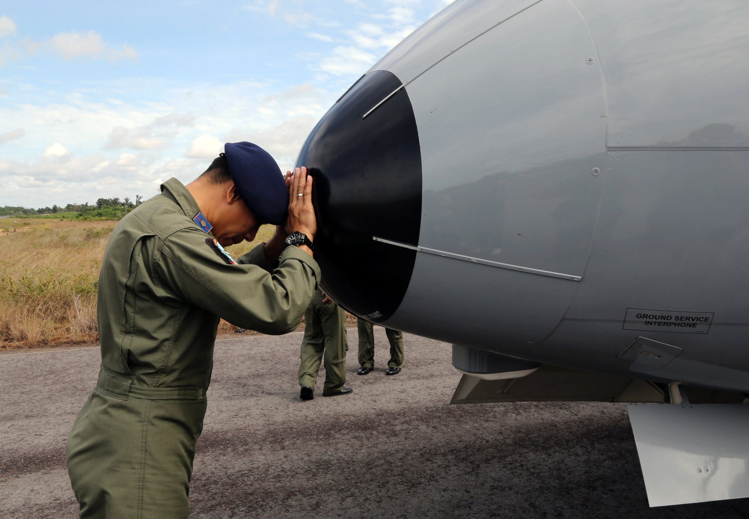 PHOTO: A crew member of Indonesian Navy CN-235 airplane prays prior to the start of a search operation for the missing AirAsia flight 8501 at the airport in Pangkal Pinang, Bangka Island, Indonesia, Dec. 30, 2014. 