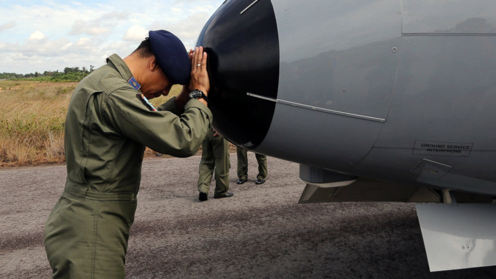 PHOTO: A crew member of Indonesian Navy CN-235 airplane prays prior to the start of a search operation for the missing AirAsia flight 8501 at the airport in Pangkal Pinang, Bangka Island, Indonesia, Dec. 30, 2014. 