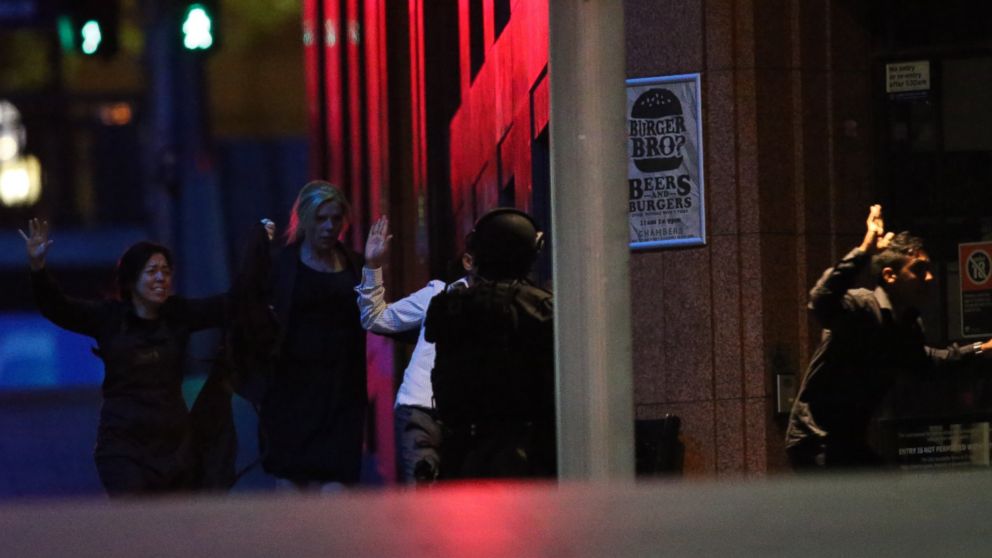 PHOTO: Hostages run towards armed tactical response police as they run to freedom from a cafe under siege at Martin Place in the central business district of Sydney, Australia, Dec. 16, 2014. 