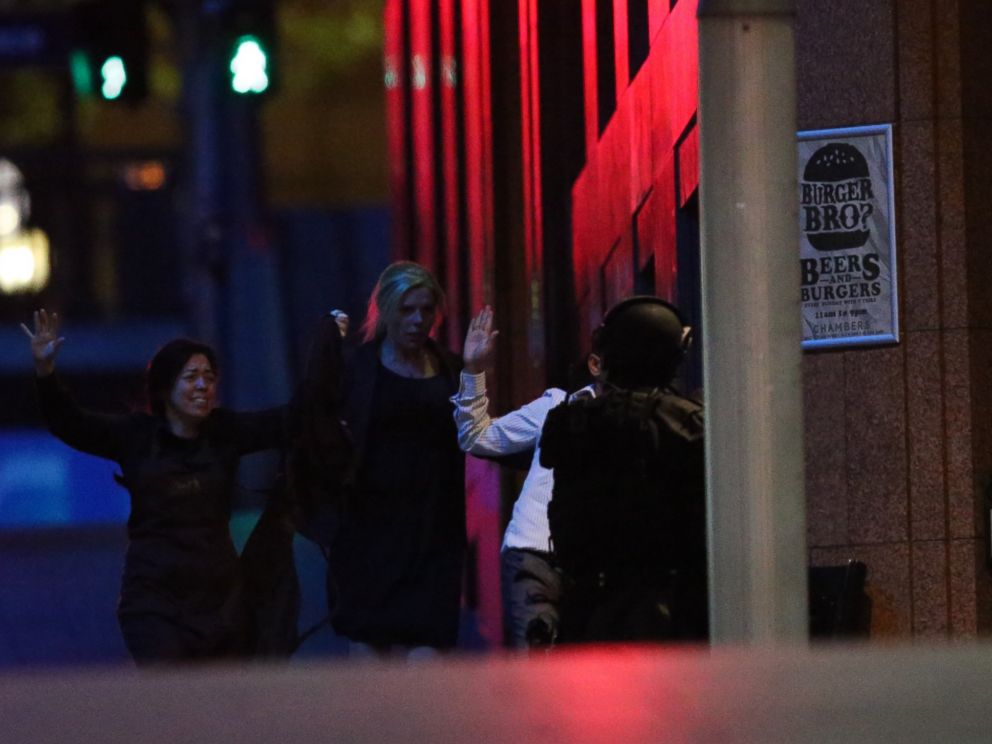 PHOTO: Hostages run towards armed tactical response police as they run to freedom from a cafe under siege at Martin Place in the central business district of Sydney, Australia, Dec. 16, 2014.