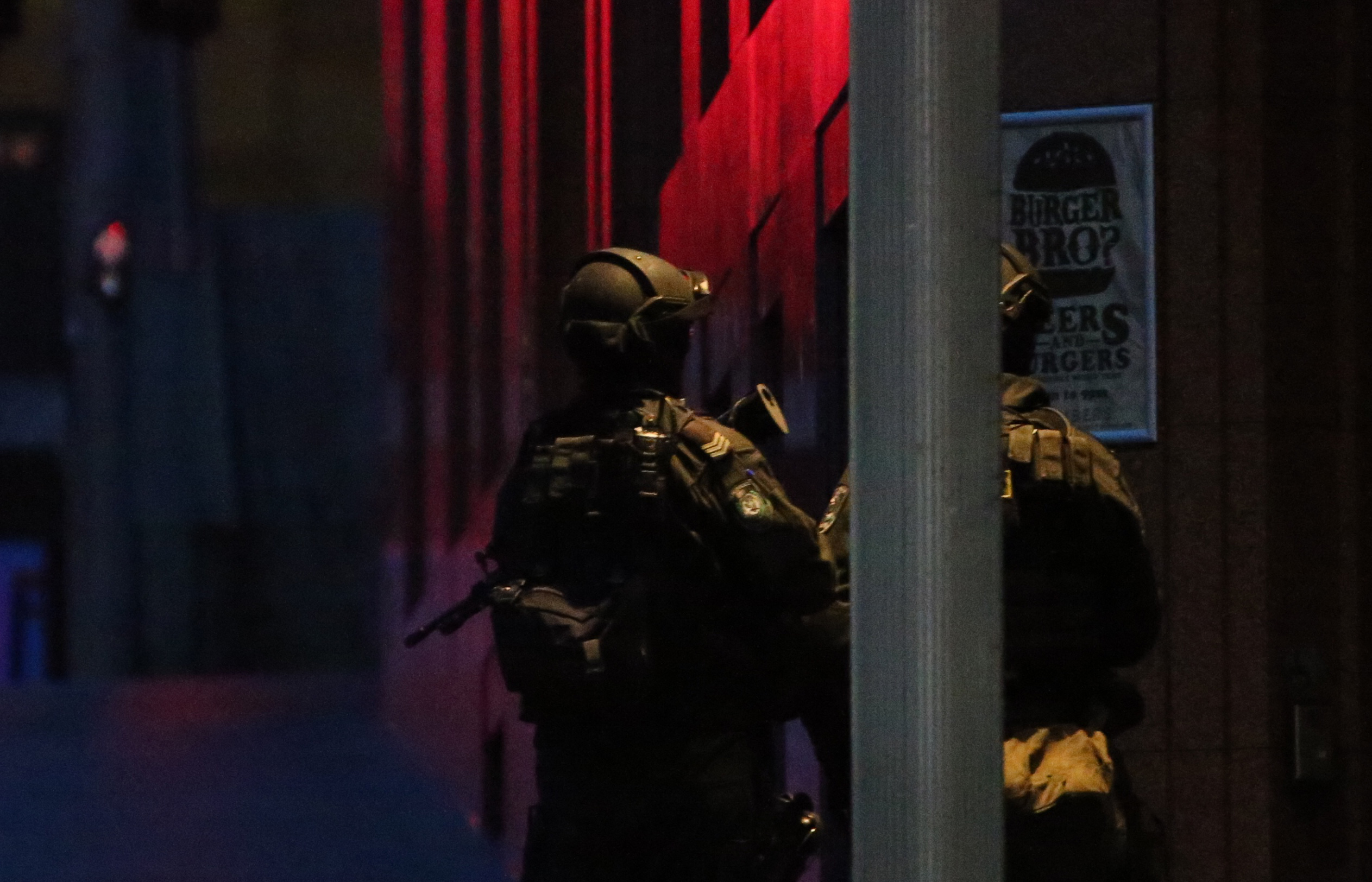 PHOTO: Armed tactical response police personnel stand watch into the evening near a cafe under siege by a gunman at Martin Place in the central business district of Sydney, Australia, Dec. 15, 2014. 