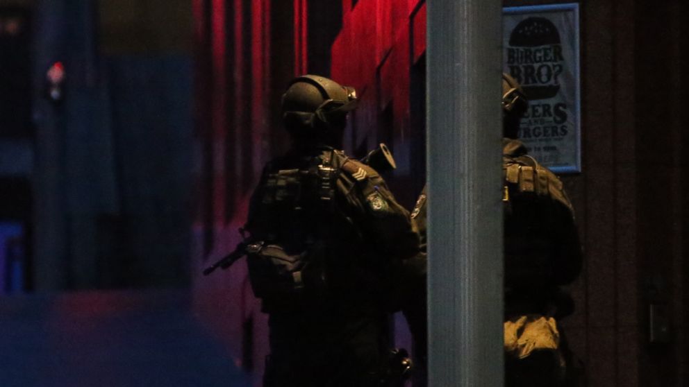 PHOTO: Armed tactical response police personnel stand watch into the evening near a cafe under siege by a gunman at Martin Place in the central business district of Sydney, Australia, Dec. 15, 2014.