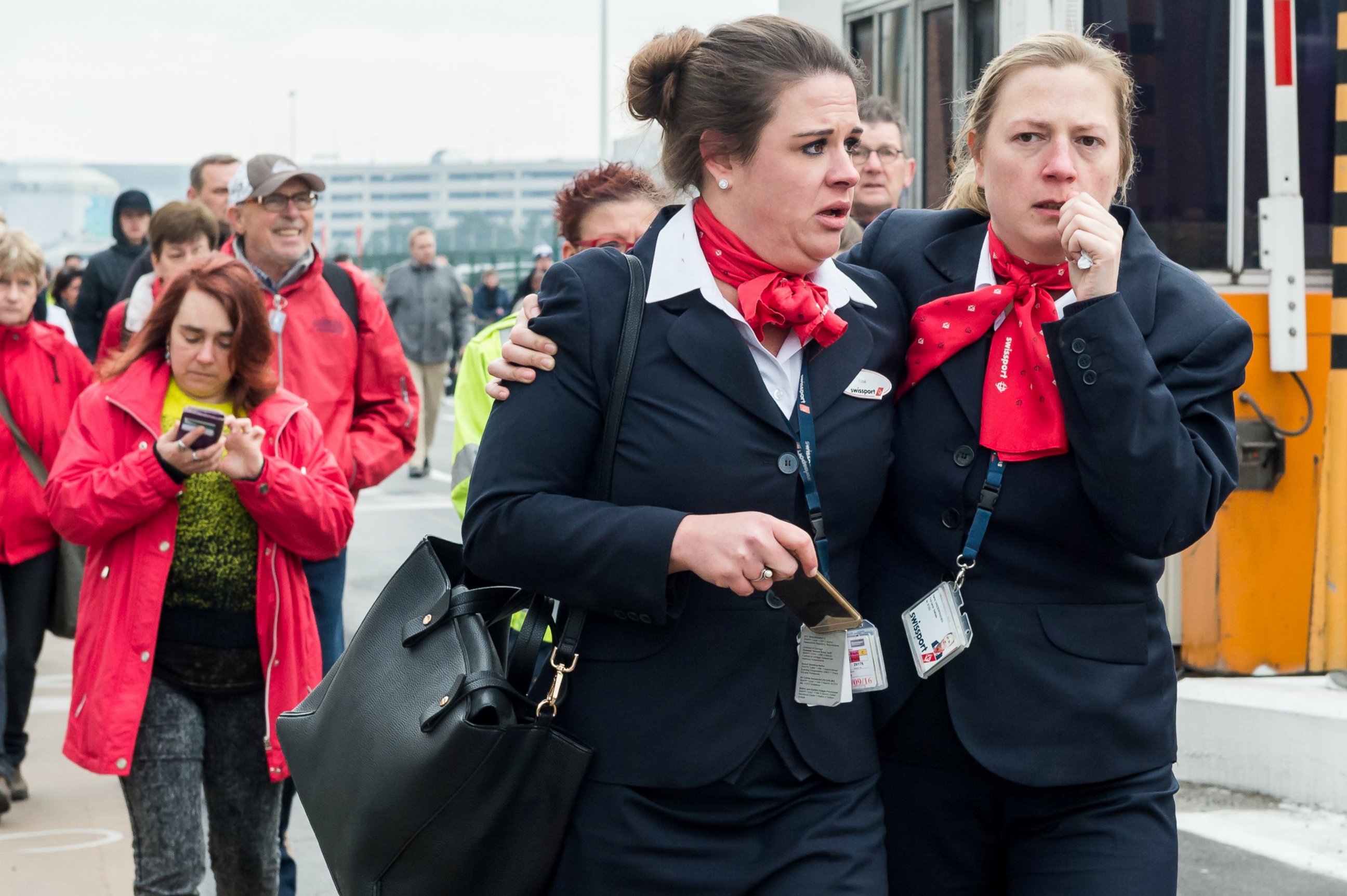 PHOTO: People react as they walk away from Brussels airport after explosions rocked the facility in Brussels, Belgium Tuesday March 22, 2016.