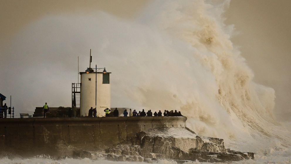 Waves break over Porthcawl harbour, south Wales, as the region continues to be battered by high winds and heavy rain. Britain's weather service says it sees the tentacles of climate change in a spate of storms and floods battering the country, but has stopped short of saying warming directly caused the extreme storms.