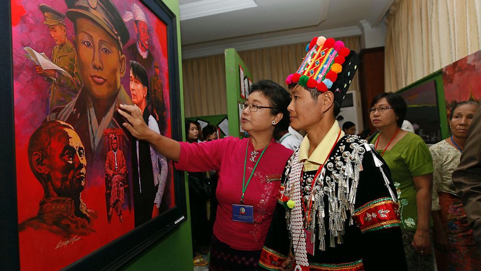 Visitors look at a painting of Burma's opposition leader Aung San Suu Kyi and her late father Gen. Aung San displayed at an event marking the 25th anniversary of Burma's pro-democracy uprising, at the Myanmar Convention Center in Yangon, Burma, Aug. 6, 2013.