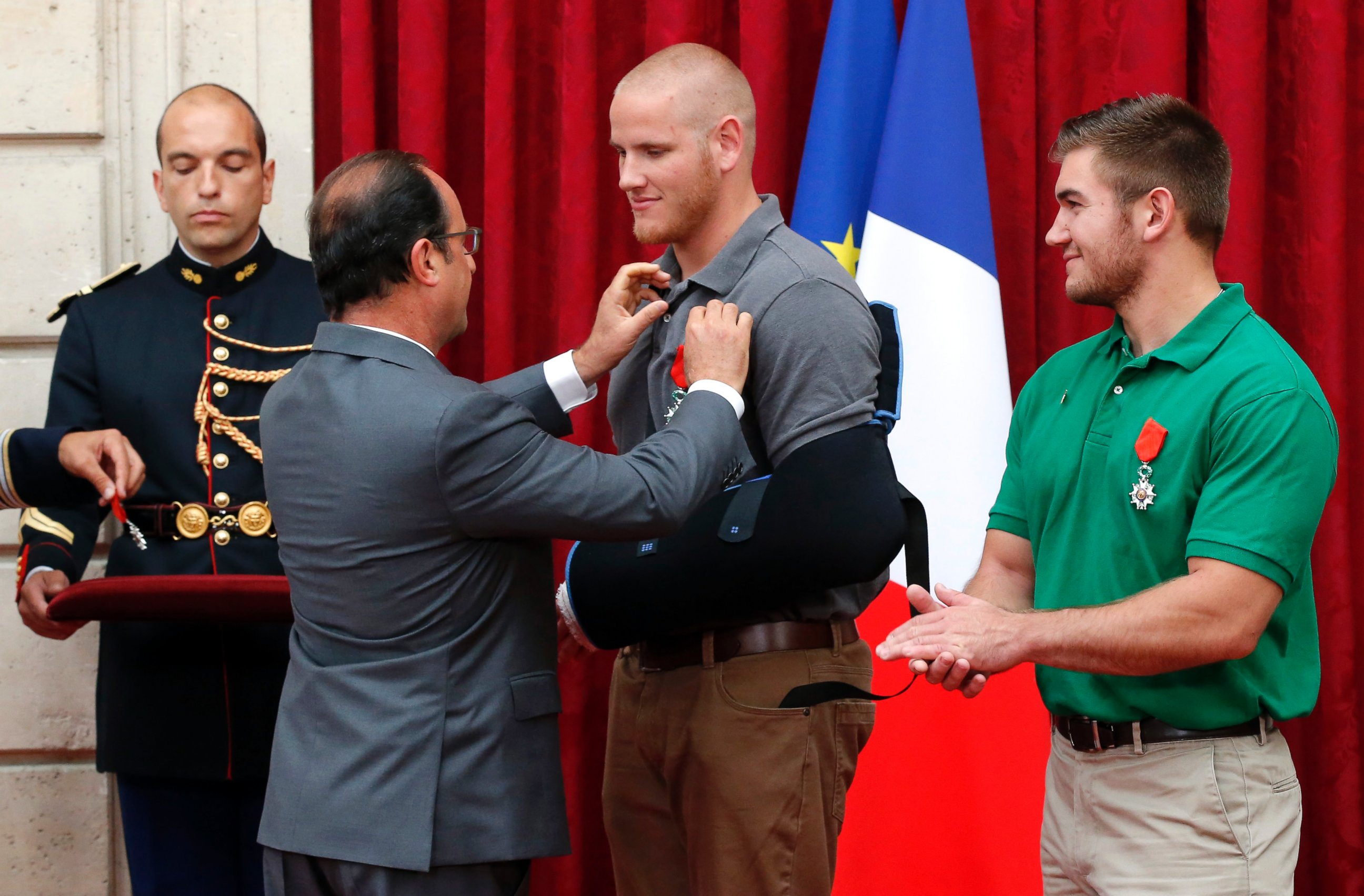 PHOTO: French President Francois Hollande awards U.S. Airman Spencer Stone while Alek Skarlatos applauds at the Elysee Palace, Aug.24, 2015 in Paris.