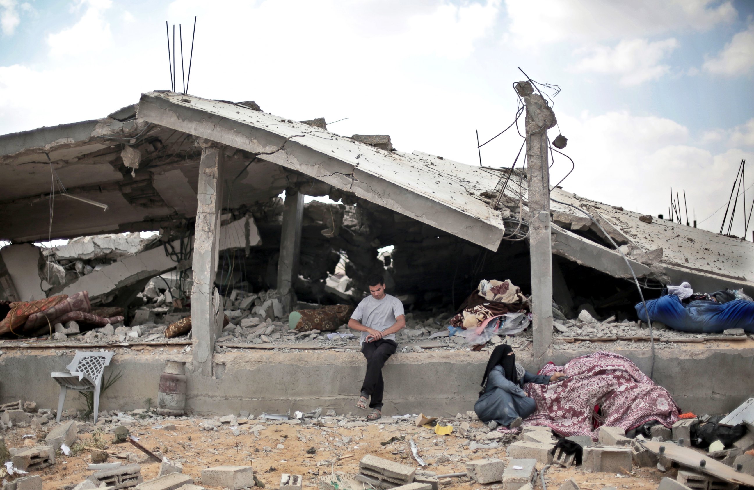 PHOTO: A Palestinian sits in front of a destroyed house in Rafah's district of Shawkah in the southern Gaza Strip, Aug. 5, 2014.