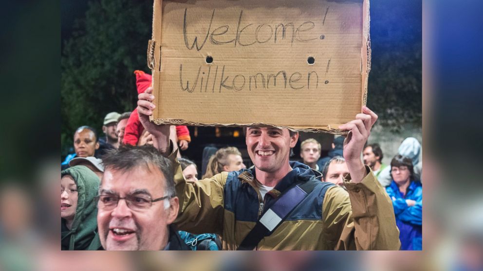 PHOTO: A man holds a "Welcome" sign for arriving refugees at the train station in Saalfeld, central Germany, Sept. 5, 2015.