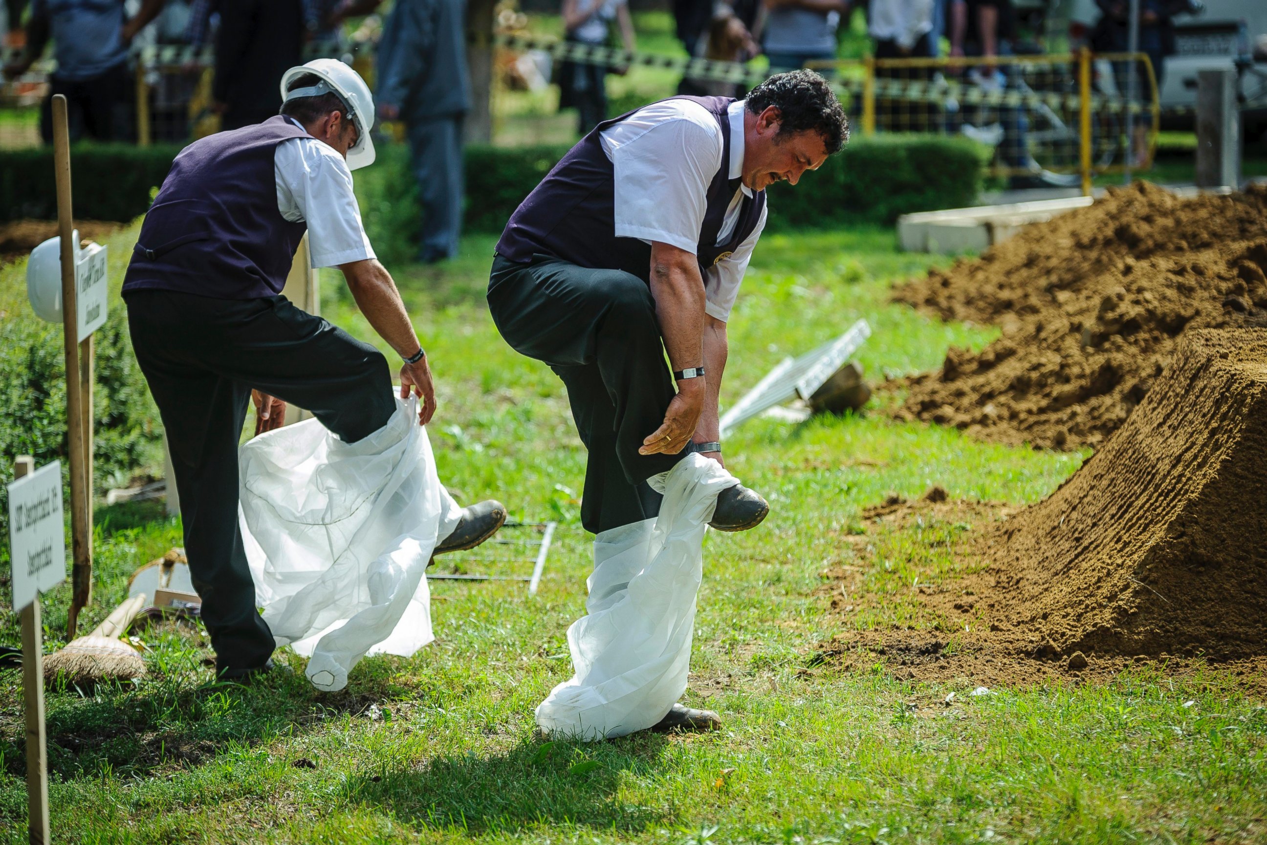 PHOTO: Gravediggers take off their disposable overalls during the first National Grave Digging competition at the public cemetery of Debrecen, Hungary, June 3, 2016.
