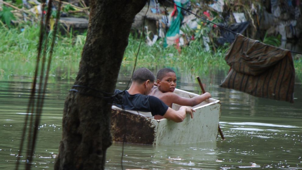 Two boys float in an old wooden box in an area flooded by heavy rains caused by Hurricane Matthew, in La Puya slum, in the Arroyo Hondo creek in Santo Domingo, Dominican Republic, Oct. 4, 2016.