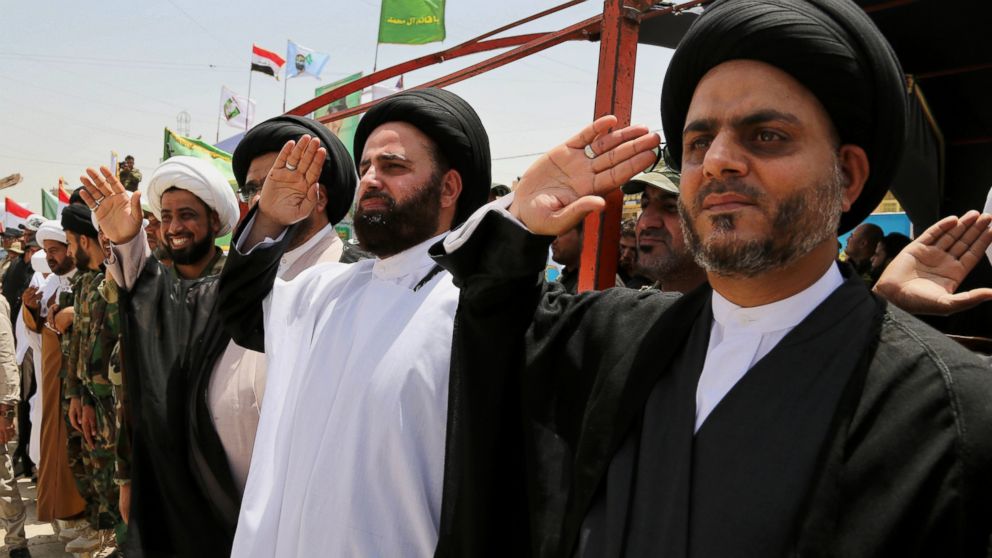 Sadrist officials salute volunteers of the newly formed "Peace Brigades" in a parade in the Shiite stronghold of Sadr City, Baghdad, Iraq, Saturday, June 21, 2014. Thousands of Shiite militiamen have paraded in Baghdad and several other cities in southern Iraq with heavy weaponry, signaling their readiness to take on Sunni militants who control a large chunk of the country's north.