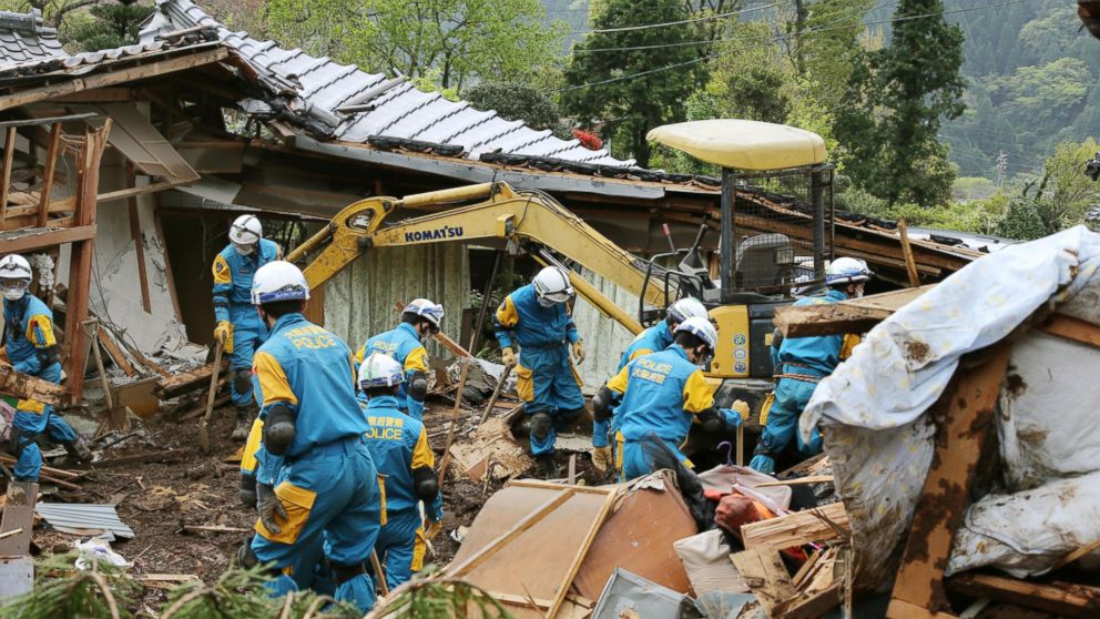 Police officers search for missing persons near houses destroyed by landslide in Minamiaso, Kumamoto prefecture, Japan Sunday, April 17, 2016. After two nights of earthquakes, flattened houses and triggered major landslides in southern Japan, 91,000 people had evacuated from their homes, according to a Kumamoto prefectural official.