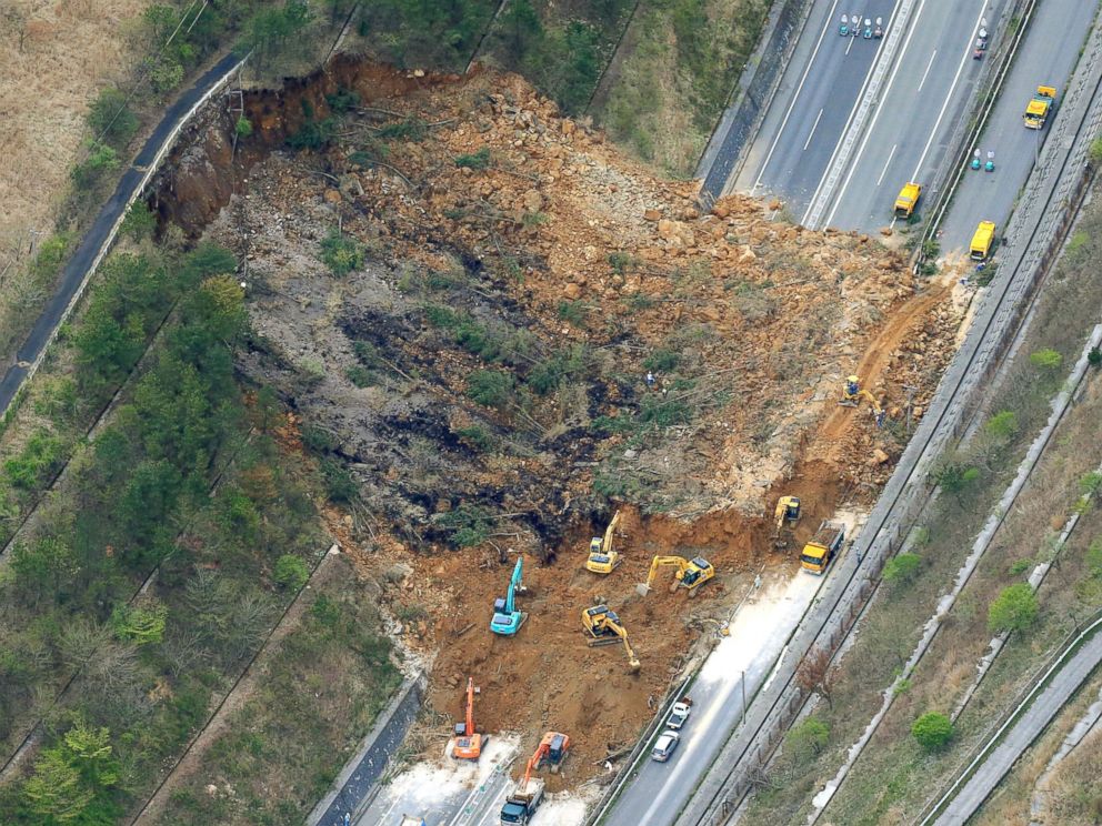 PHOTO: Heavy machinery works recovery efforts of Oita Expressway damaged by a landslide following an earthquake in Yufu, Oita prefecture, Japan, April 16, 2016.