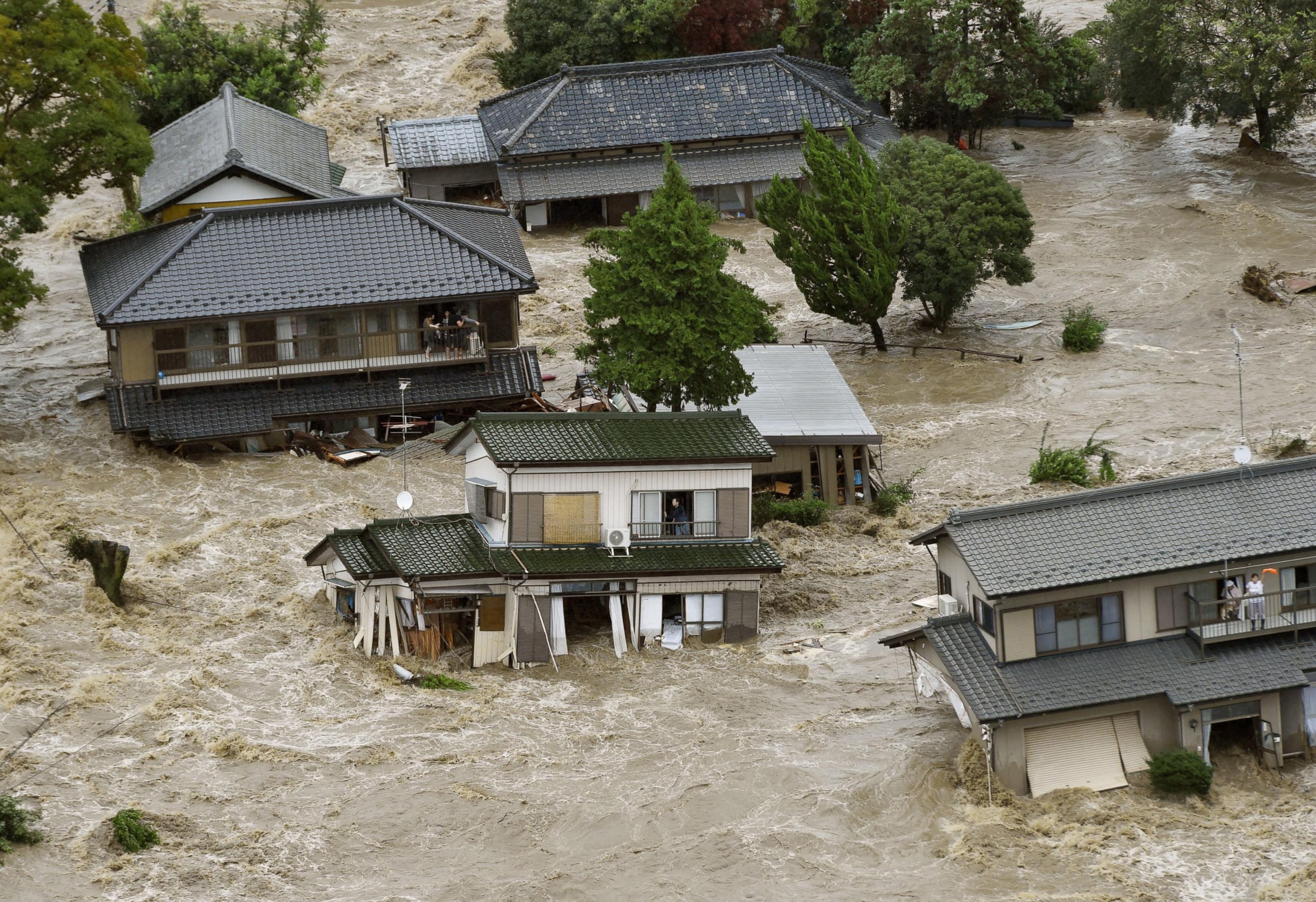 PHOTO: People inside houses wait to be rescued as the houses are submerged in water flooded from a river in Joso, Ibaraki prefecture, northeast of Tokyo, Sept. 10, 2015. 