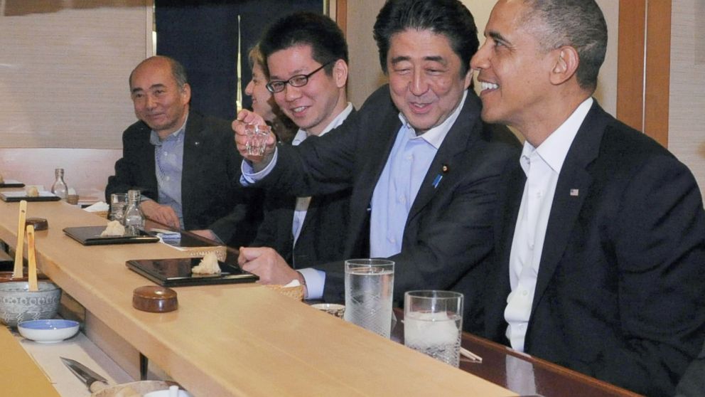In this April 23, 2014 photo taken and released by Japan's Cabinet Public Relations Office, Japanese Prime Minister Shinzo Abe, second right, shares a laugh with U.S. President Barack Obama as they have dinner at Sukiyabashi Jiro sushi restaurant in Tokyo.