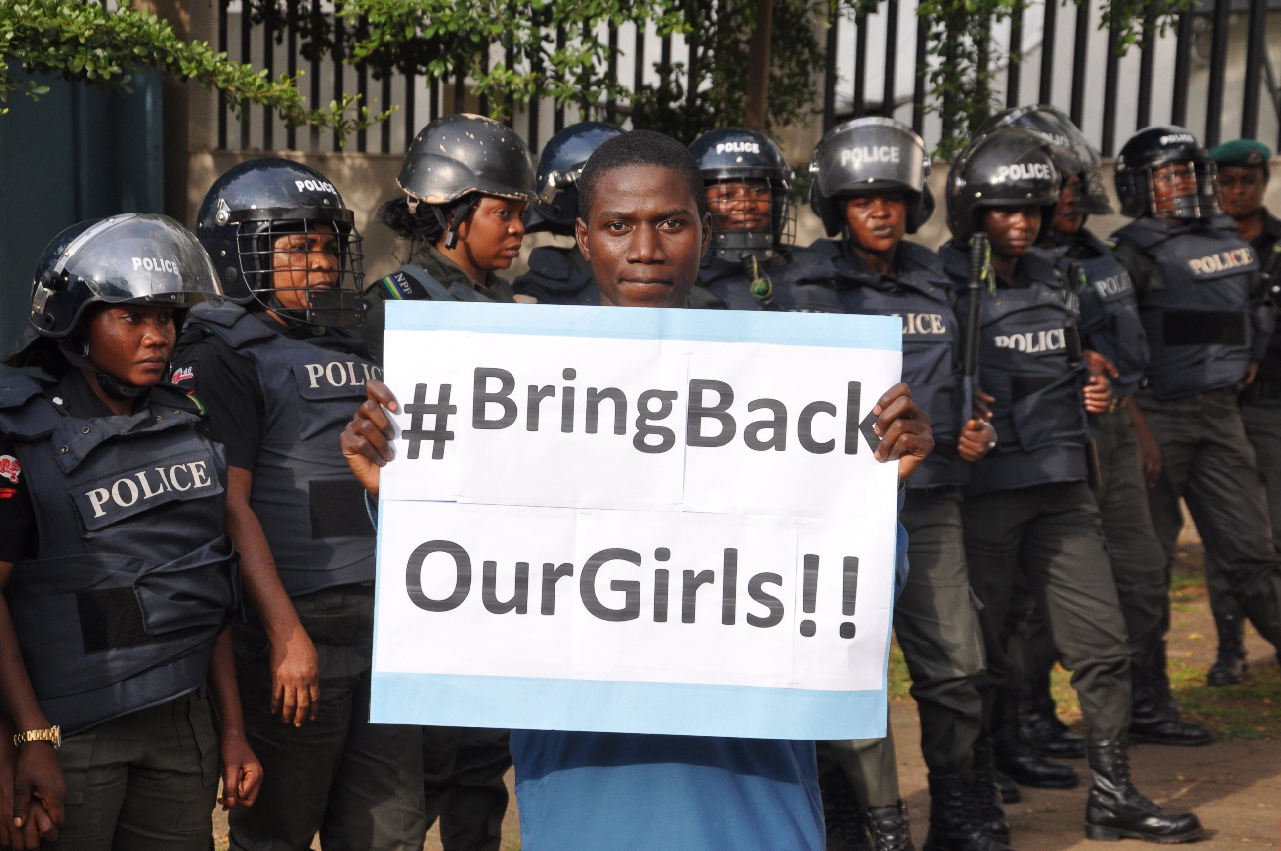 PHOTO: A man poses with a sign in front of police officers during a demonstration calling on the government to rescue the girls taken from the secondary school in Chibok, in Abuja, Nigeria, on Oct. 14, 2014.