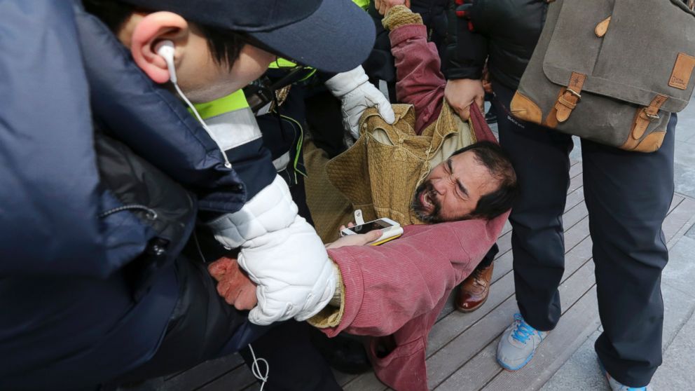PHOTO: A suspect, center, identified by police as 55-year-old Kim Ki-jong, is detained by police officers in Seoul, South Korea, March 5, 2015.
