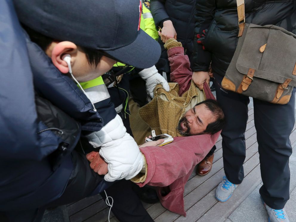 PHOTO: A suspect, center, identified by police as 55-year-old Kim Ki-jong, is detained by police officers in Seoul, South Korea, March 5, 2015.