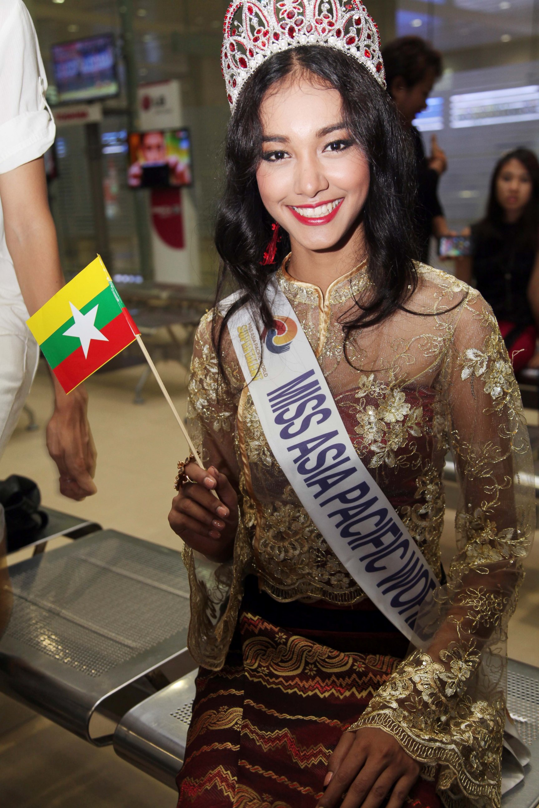 PHOTO: In this June 5, 2014 file photo, Myanmar model May Myat Noe, winner of Miss Asia Pacific World 2014 pageant, waves a miniature flag of the country upon her arrival at Yangon International Airport in Yangon, Myanmar. 