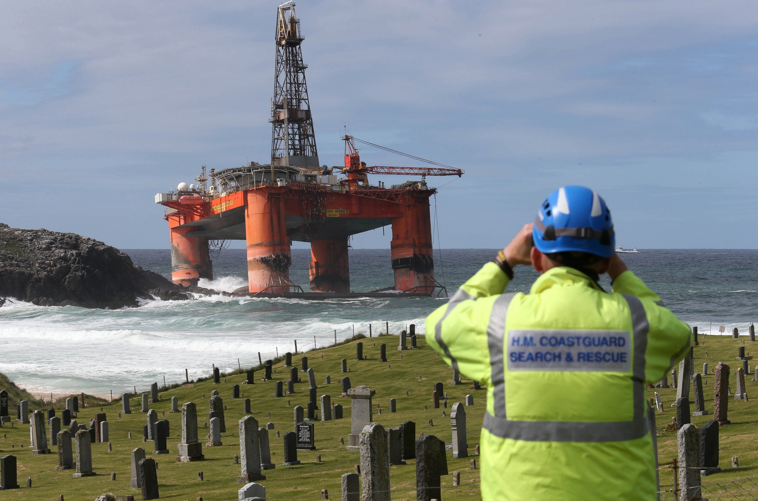 PHOTO: A coastguard official monitors the Transocean Winner drilling rig off the coast of the Isle of Lewis, Scotland, after it ran aground in severe weather conditions, Aug. 9, 2016.
