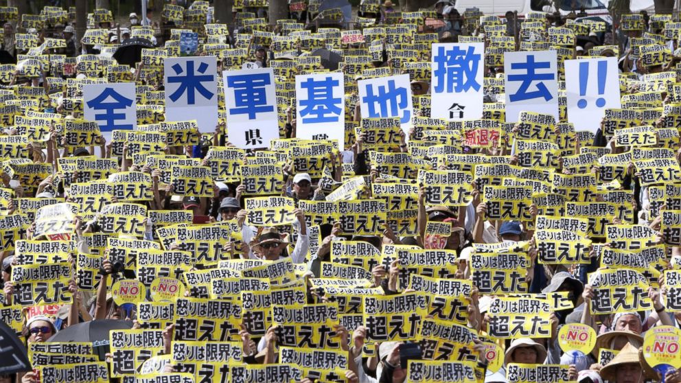 Protesters hold placards that read: "Our anger went over our own limit" and "Remove all U.S. bases!!" during a protest rally against the presence of U.S. military bases on the southwestern island of Okinawa in Naha, Okinawa, June 19, 2016.