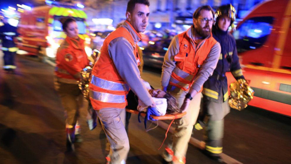 A woman is evacuated from the Bataclan theater after a shooting in Paris, Nov. 13, 2015.