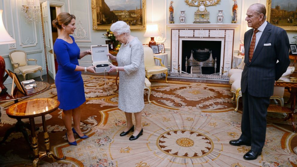 Queen Elizabeth II is presented with a lifetime achievement award for her devotion to equestrian sport by Princess Haya of Jordan as the Duke of Edinburgh looks on, at Buckingham Palace, London on Nov. 26, 2014.