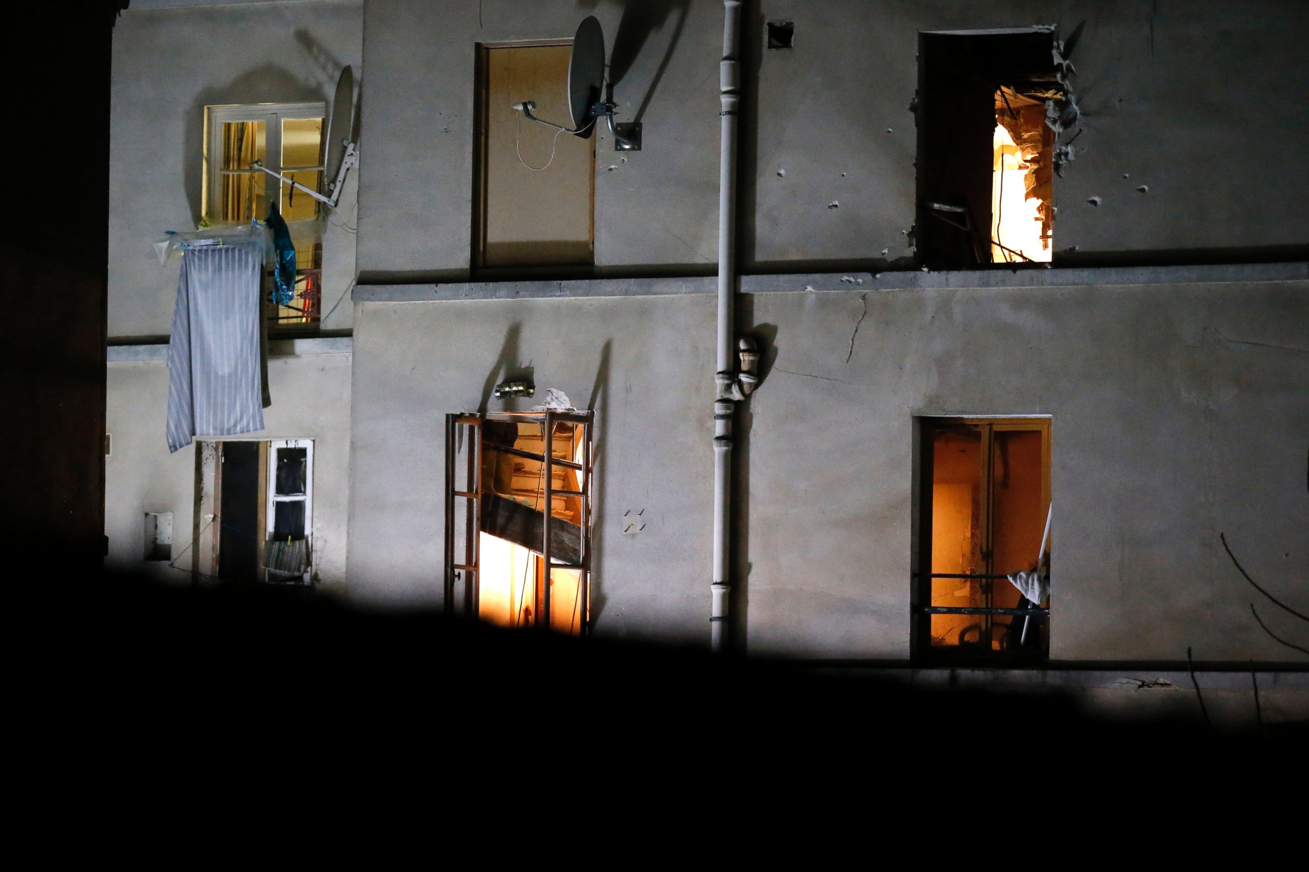 PHOTO: Bullet holes and smashed windows are seen on the back side of a building after it was raided by security forces in Saint-Denis, near Paris, Nov. 18, 2015.