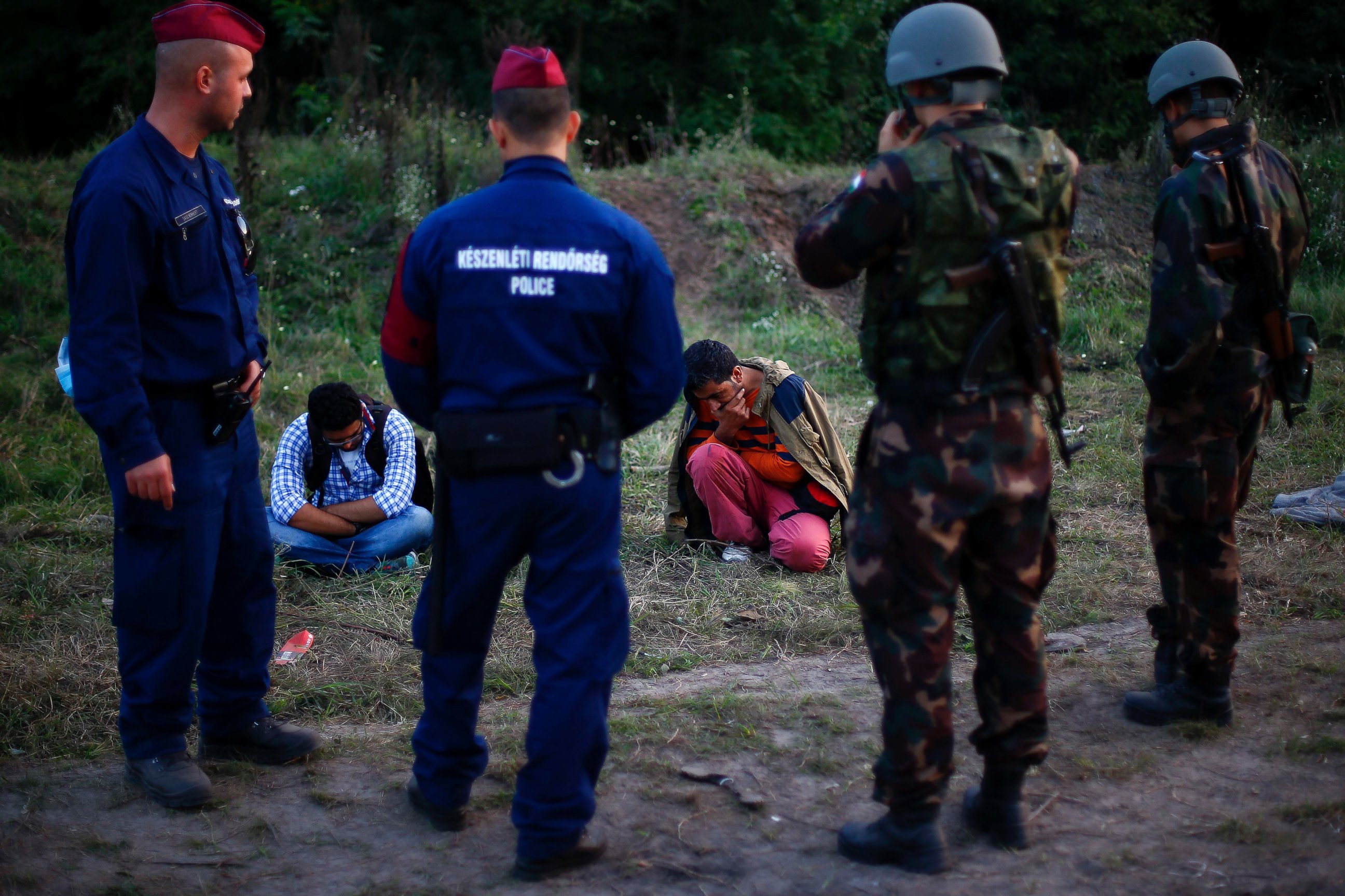 PHOTO: Migrants sit on the ground after they were arrested by Hungarian authorities after they tried to cross the border between Serbia and Hungary in Roszke, Hungary, Sept. 15, 2015.