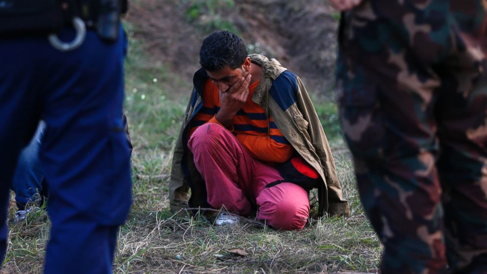 PHOTO: A migrant sits on the ground arrested by Hungarian authorities after he tried to cross the border between Serbia and Hungary in Roszke, Hungary, Sept. 15, 2015.