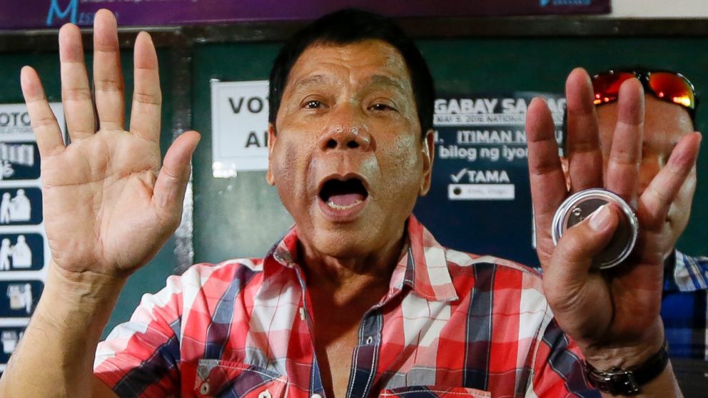 Mayor Rodrigo Duterte gestures at photographers to move out prior to voting in a polling precinct at Daniel R. Aguinaldo National High School at Matina district, his hometown in  Davao city in southern Philippines, May 9, 2016.