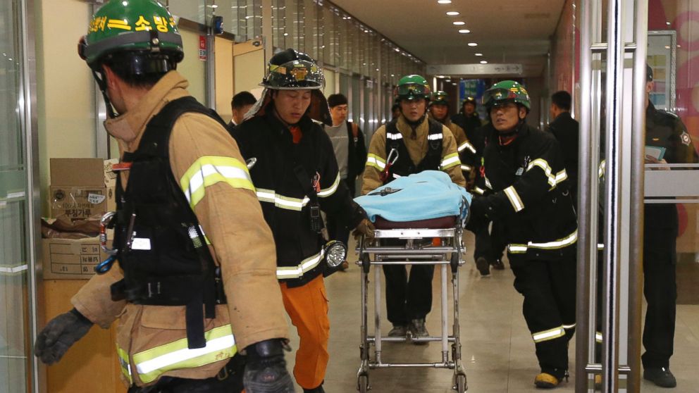PHOTO: Rescue workers carry an injured person on a stretcher after a ventilation grate was collapsed at an outdoor theater in Seongnam, south of Seoul, South Korea, on Oct. 17, 2014.
