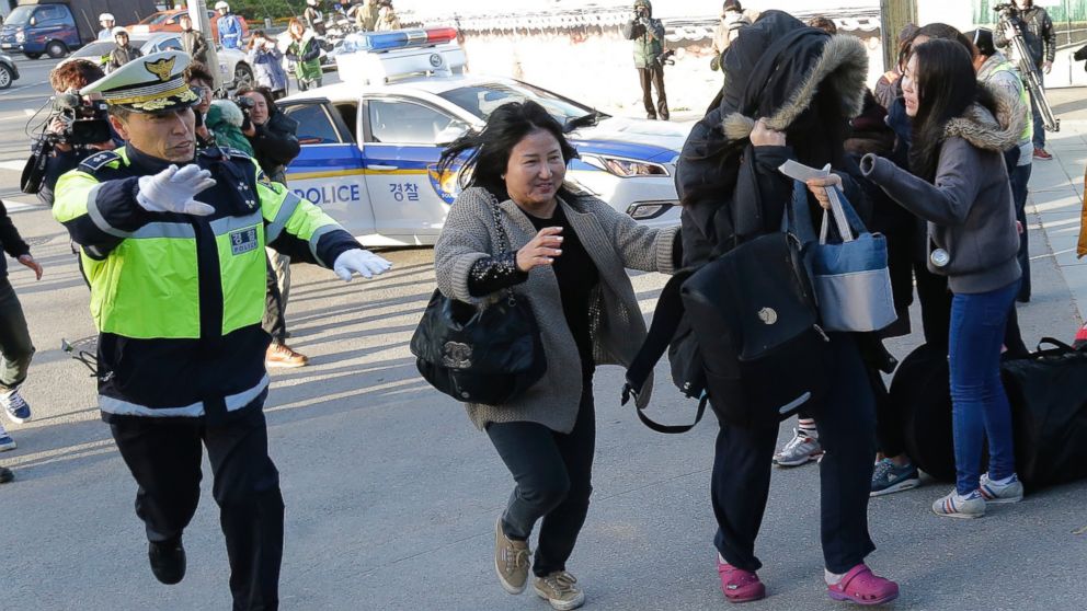 PHOTO: A student, right, and mother run toward a gate, which is about to close, as police officer escorted them for the Scholastic Aptitude Test in front of the main gate of an examination hall in Seoul, South Korea, Nov. 13, 2014. 