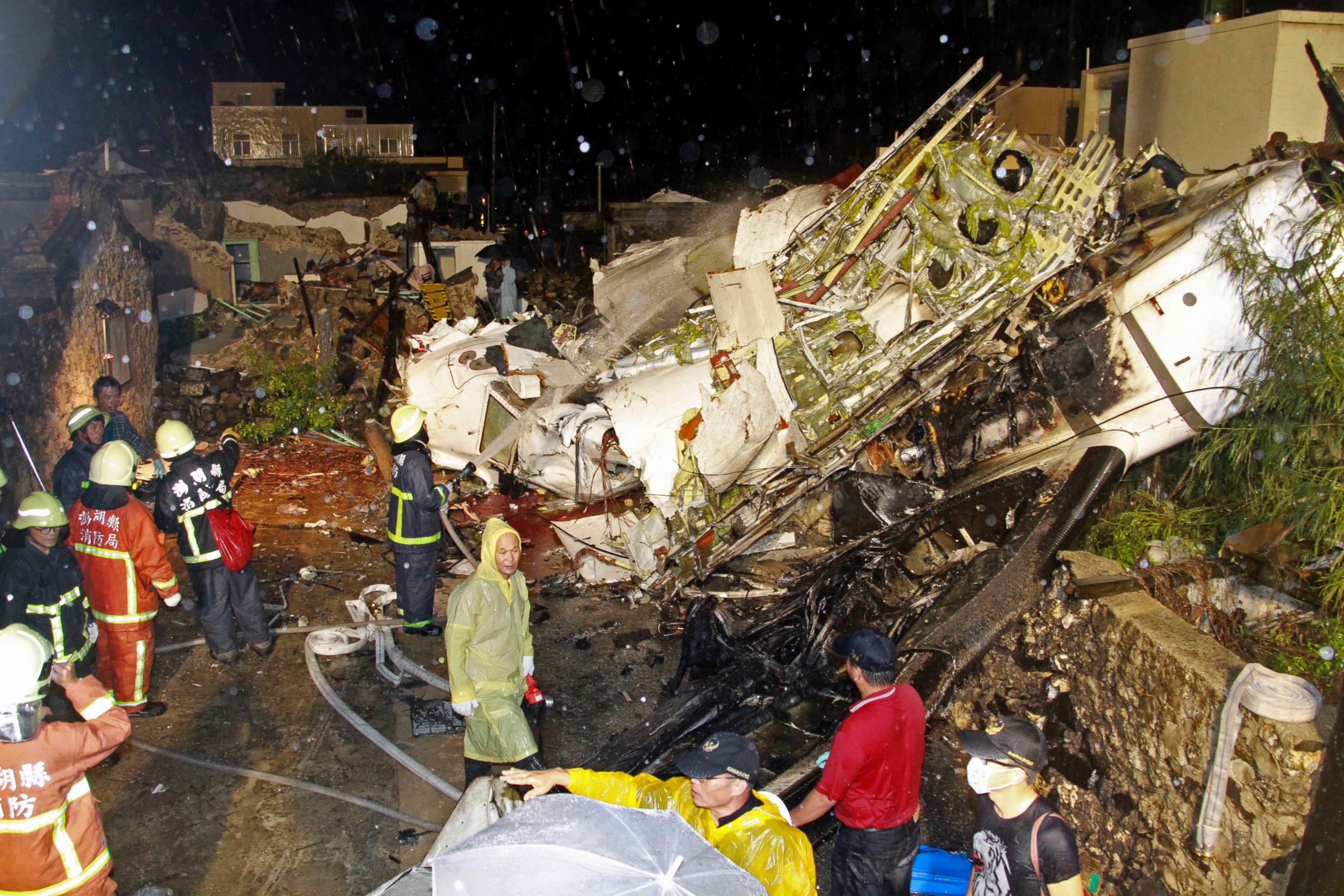 PHOTO: Rescue workers work next to the wreckage of TransAsia Airways flight GE222 which crashed while attempting to land in stormy weather on the Taiwanese island of Penghu, July 23, 2014. 