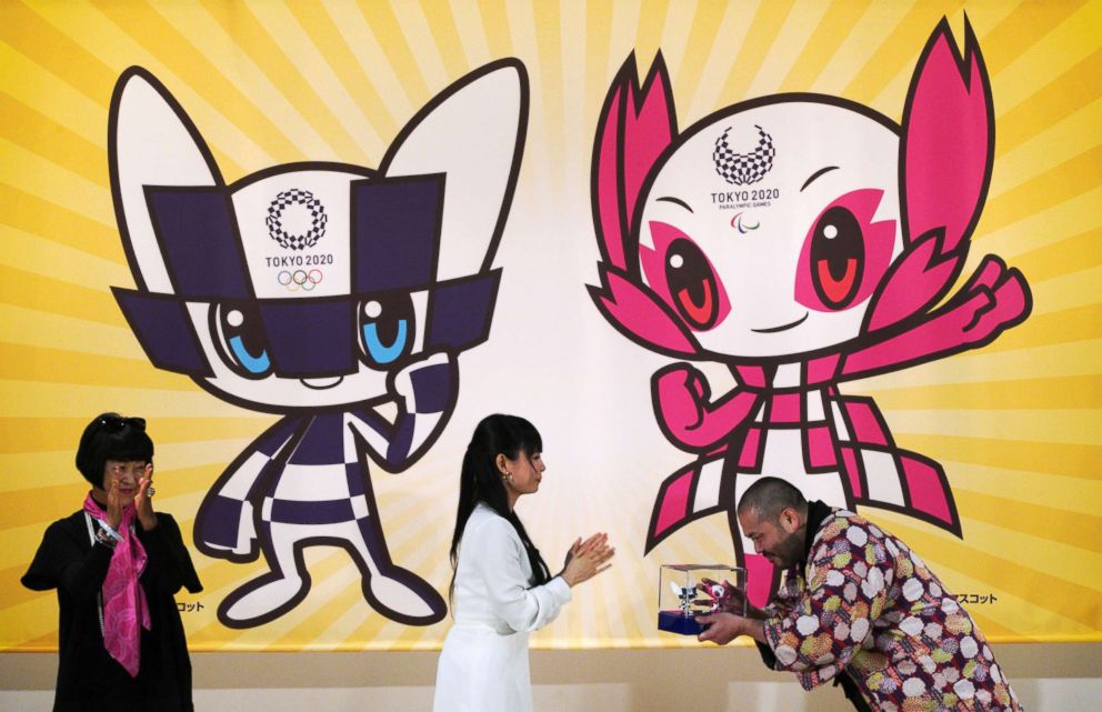 PHOTO: Ryo Taniguchi, right, the designer of the characters which will serve as mascots for the Tokyo 2020 Olympic Games and Paralympics Games, receives a 3D models of his designed characters in Tokyo, Wednesday, Feb. 28, 2018. 