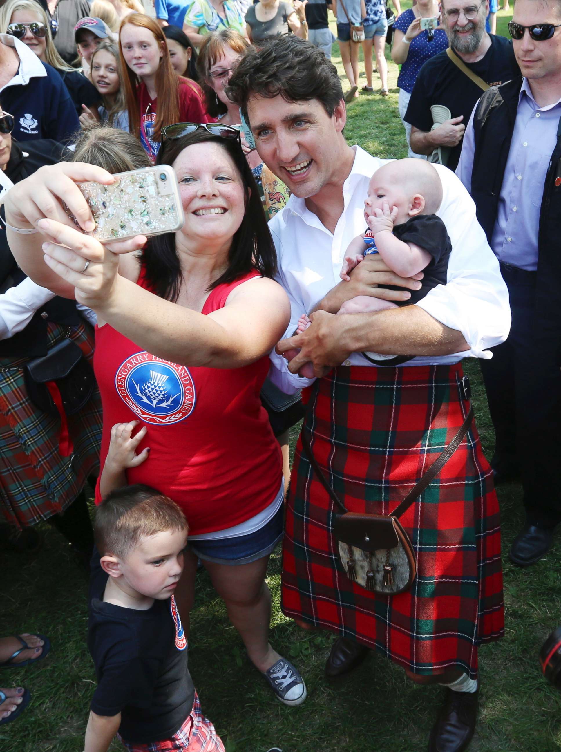 PHOTO: Canada Prime Minister Justin Trudeau, wearing kilt, has a selfie photo taken as he holds a baby while attending the 70th annual Glengarry Highland Games in Maxville, Ontario, Friday, Aug 4, 2017.