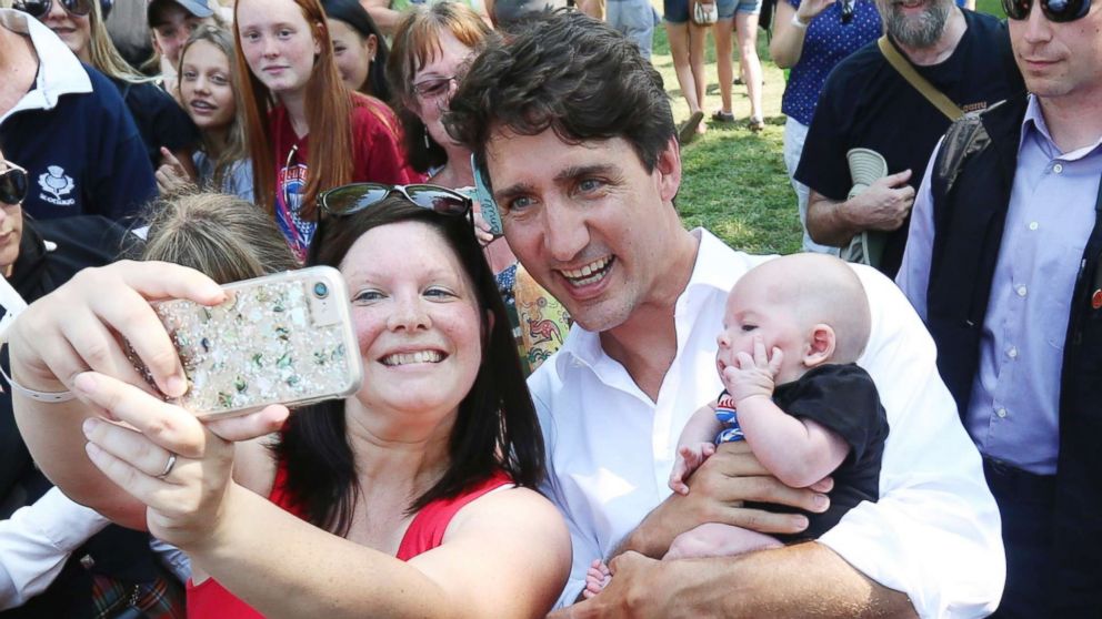 PHOTO: Canada Prime Minister Justin Trudeau, wearing kilt, has a selfie photo taken as he holds a baby while attending the 70th annual Glengarry Highland Games in Maxville, Ontario, Friday, Aug 4, 2017.
