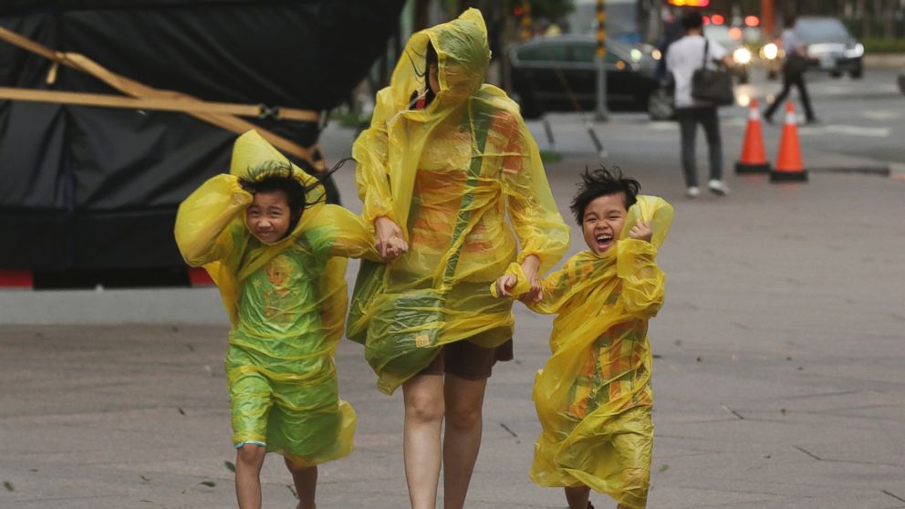 PHOTO: A woman and children brave the strong winds from Typhoon Soudelor in Taipei, Taiwan, Aug. 7, 2015. 