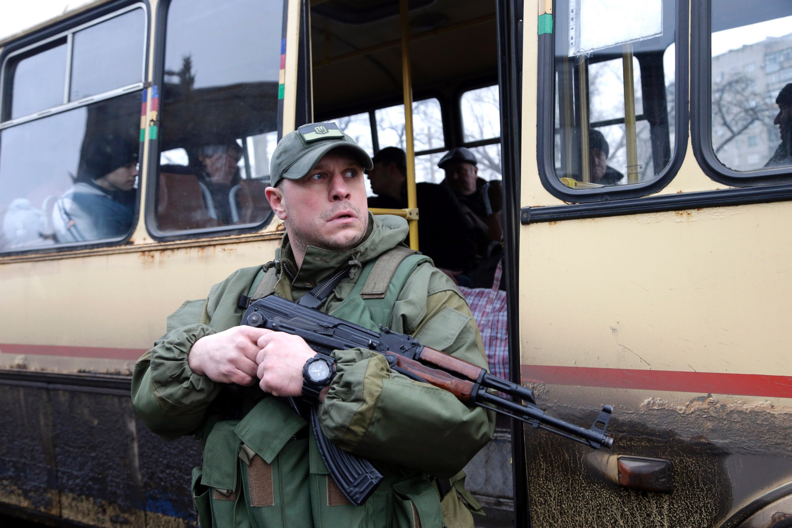PHOTO: A Ukrainian soldier holds a weapon as people wait on a bus to leave the town of Debaltseve, Ukraine on Feb. 3, 2015.