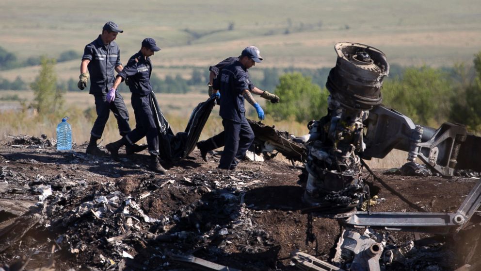 PHOTO: Ukrainian Emergency workers carry a victim's body in a plastic bag at the crash site of Malaysia Airlines Flight 17 near the village of Hrabove, Donetsk region, eastern Ukraine, July 21, 2014. 